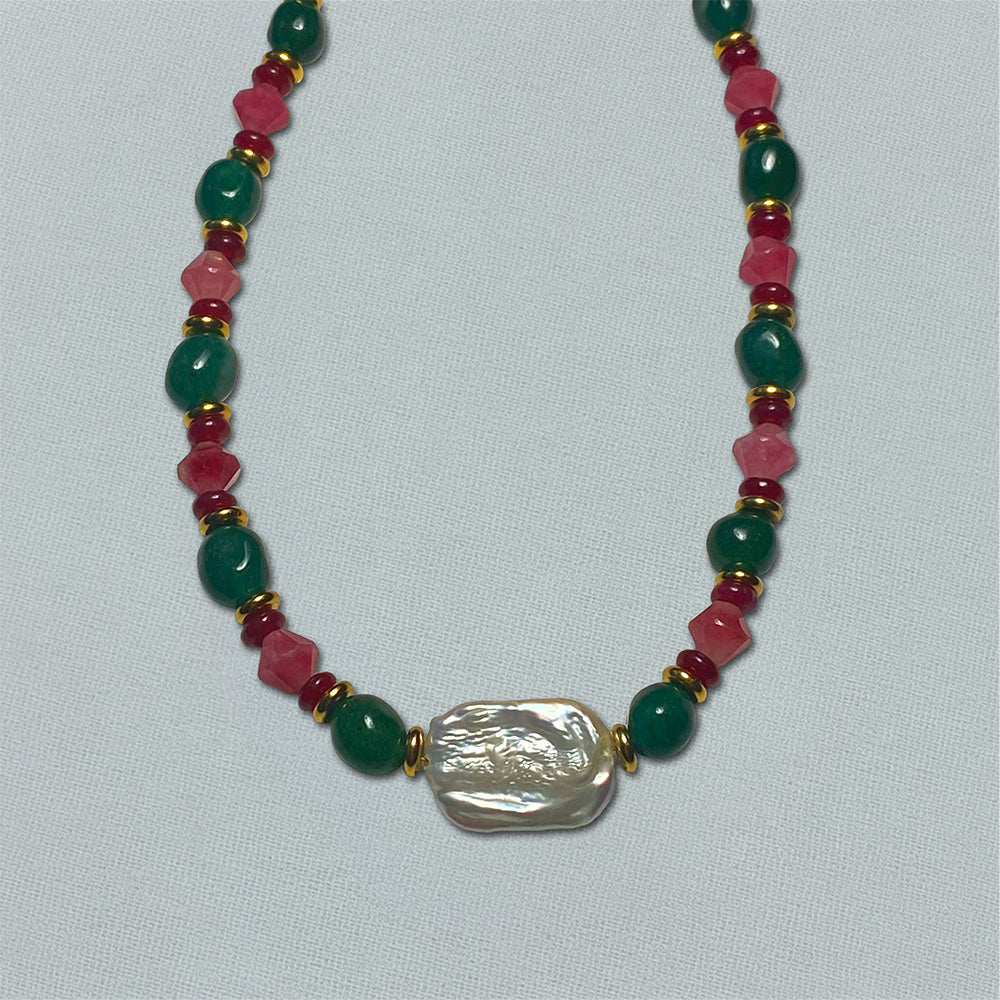 Necklace with green, pink, and gold beads on a white background