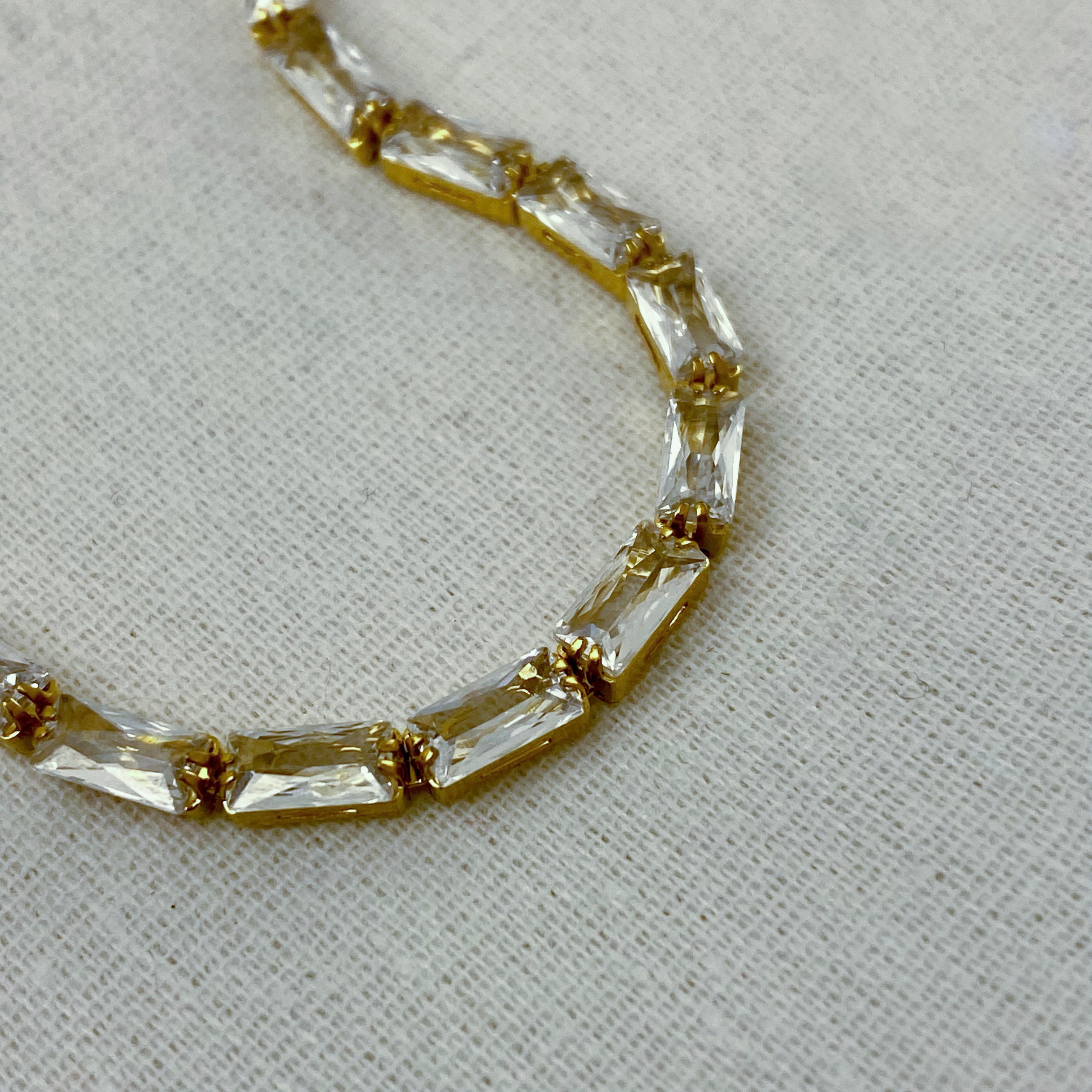 Gold-tone bracelet with rectangular clear stones.
