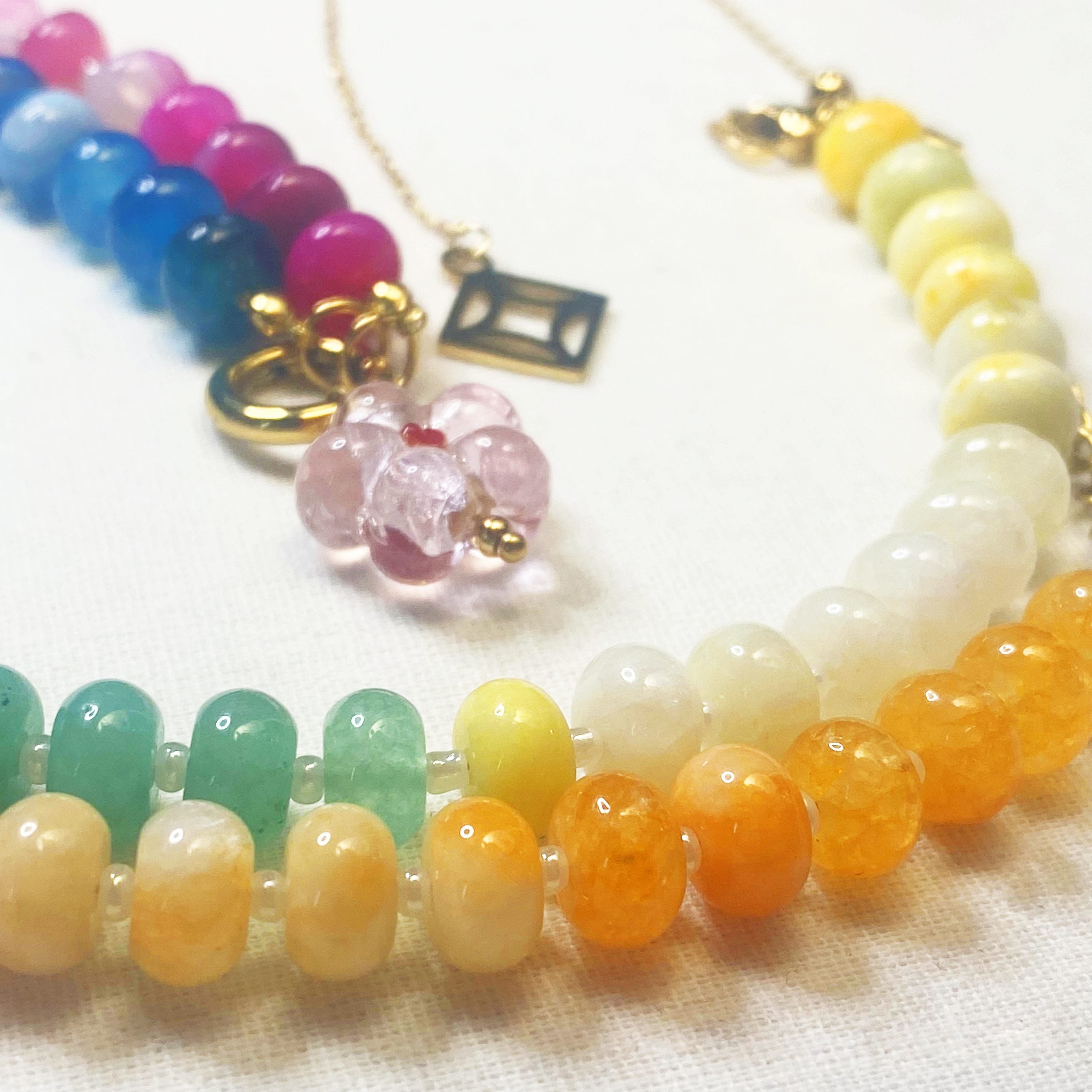 Indra Colorful beaded necklaces on a white fabric background and lumenaura jewellery 