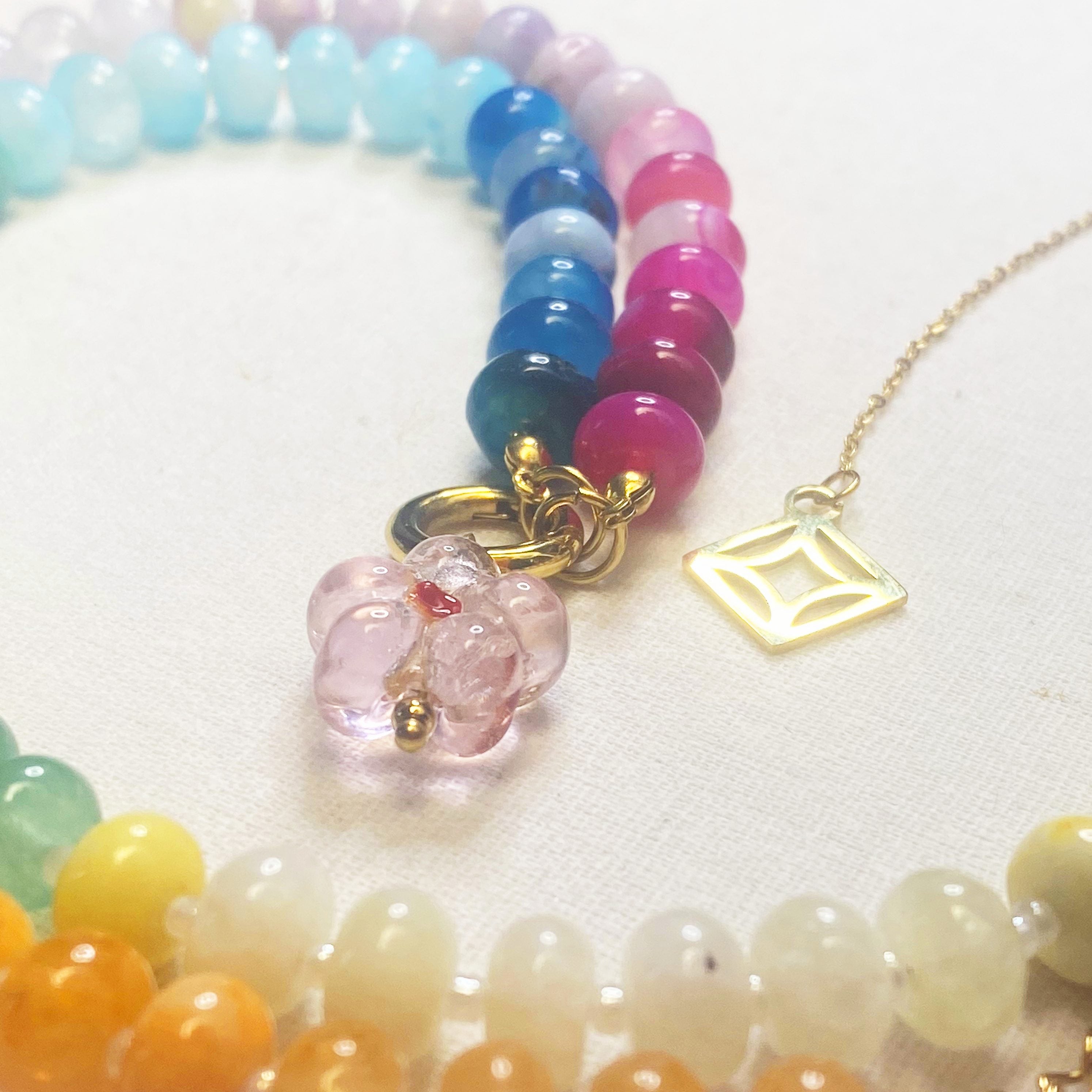 Indra Colorful beaded bracelets with a gold chain and pink pendant on a white background and lumenaura jewellery 