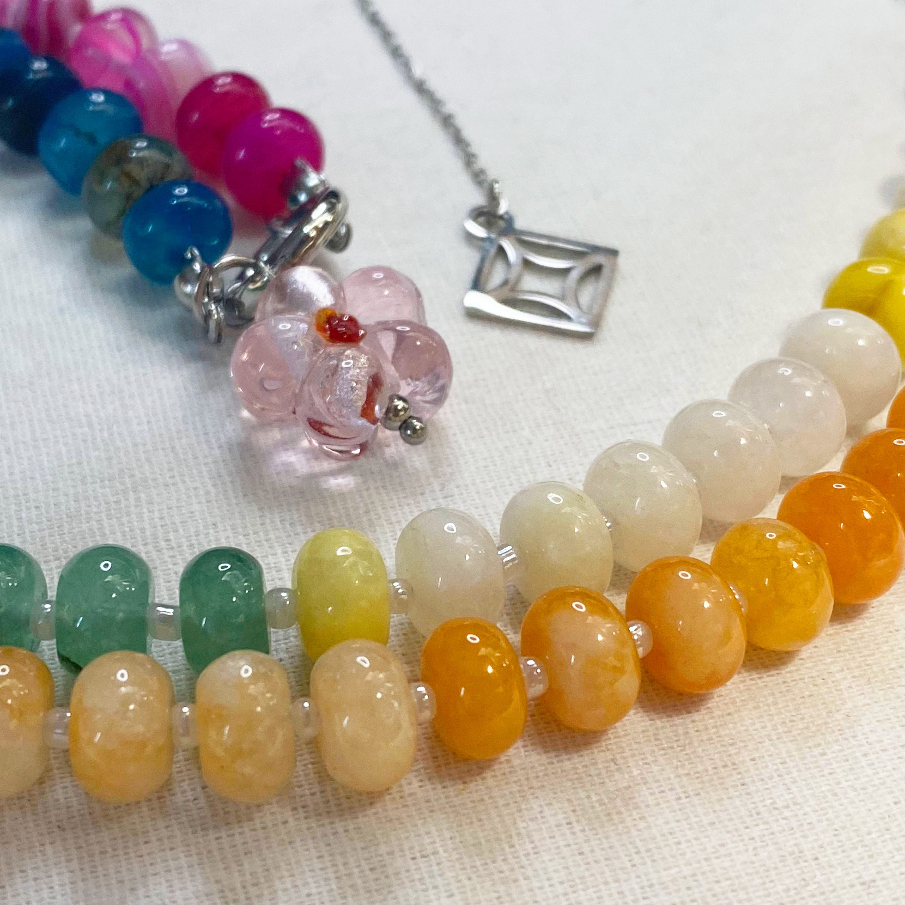 Indra Colorful beaded silver necklace on a textured fabric background and lumenaura jewellery 