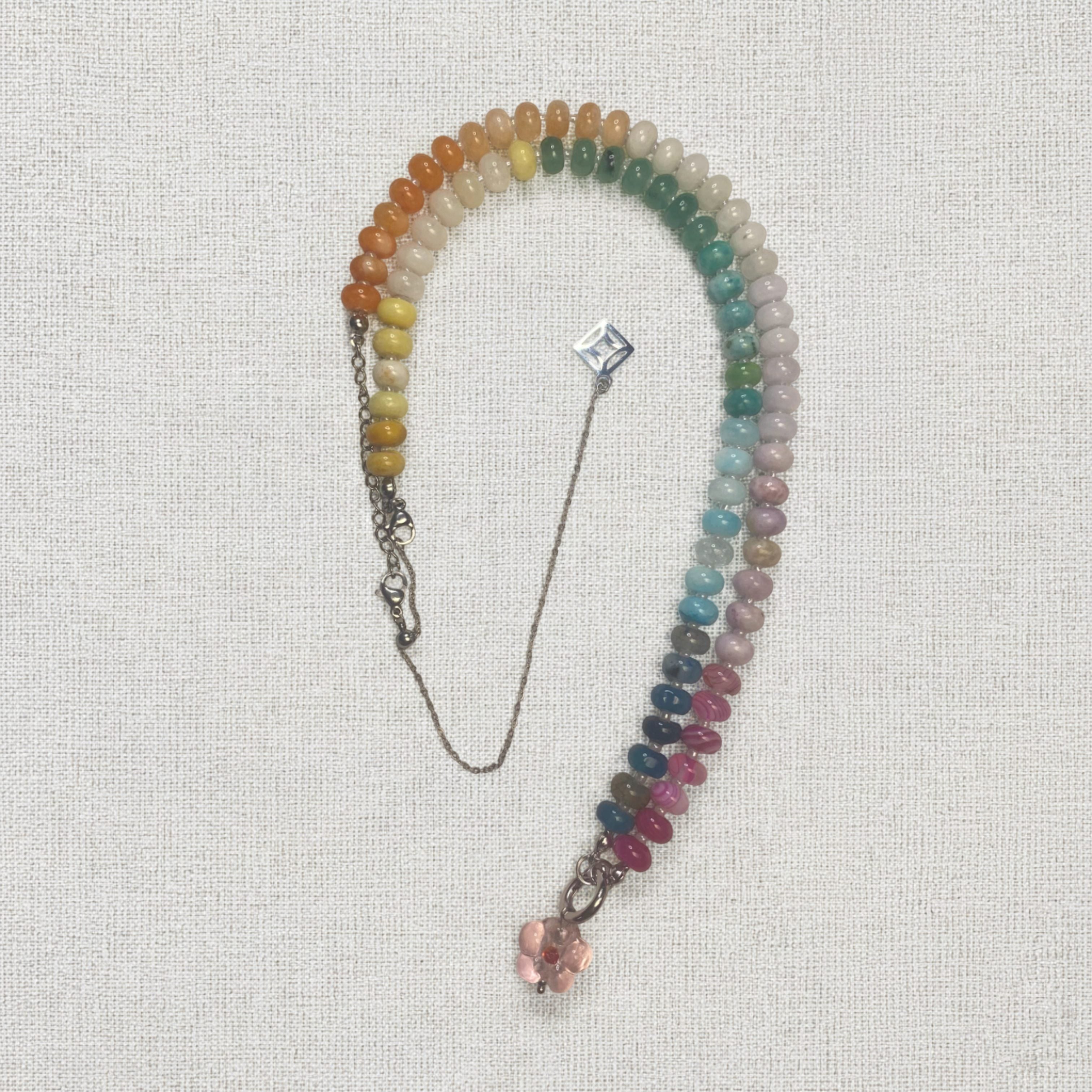 Indra Multicolored beaded bracelet with a silver chain on a textured white background and lumenaura jewellery 