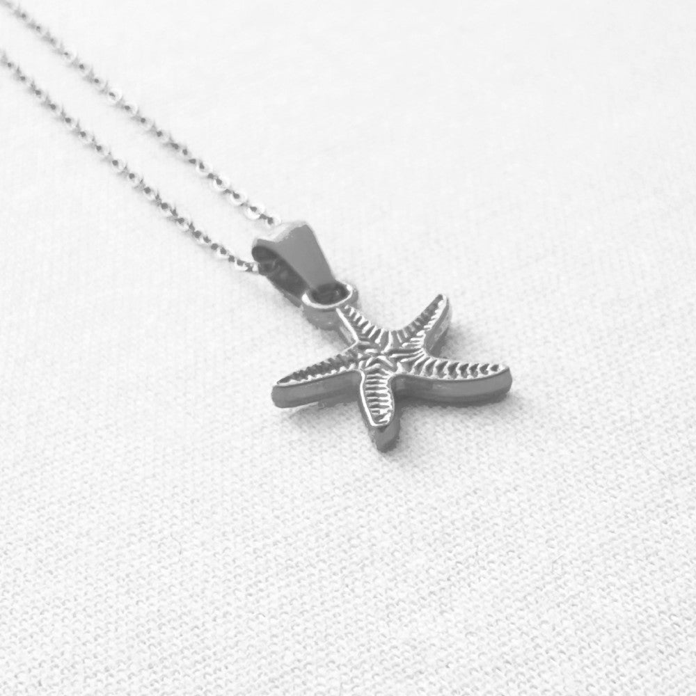 Silver Starfish pendant necklace on a light gray background