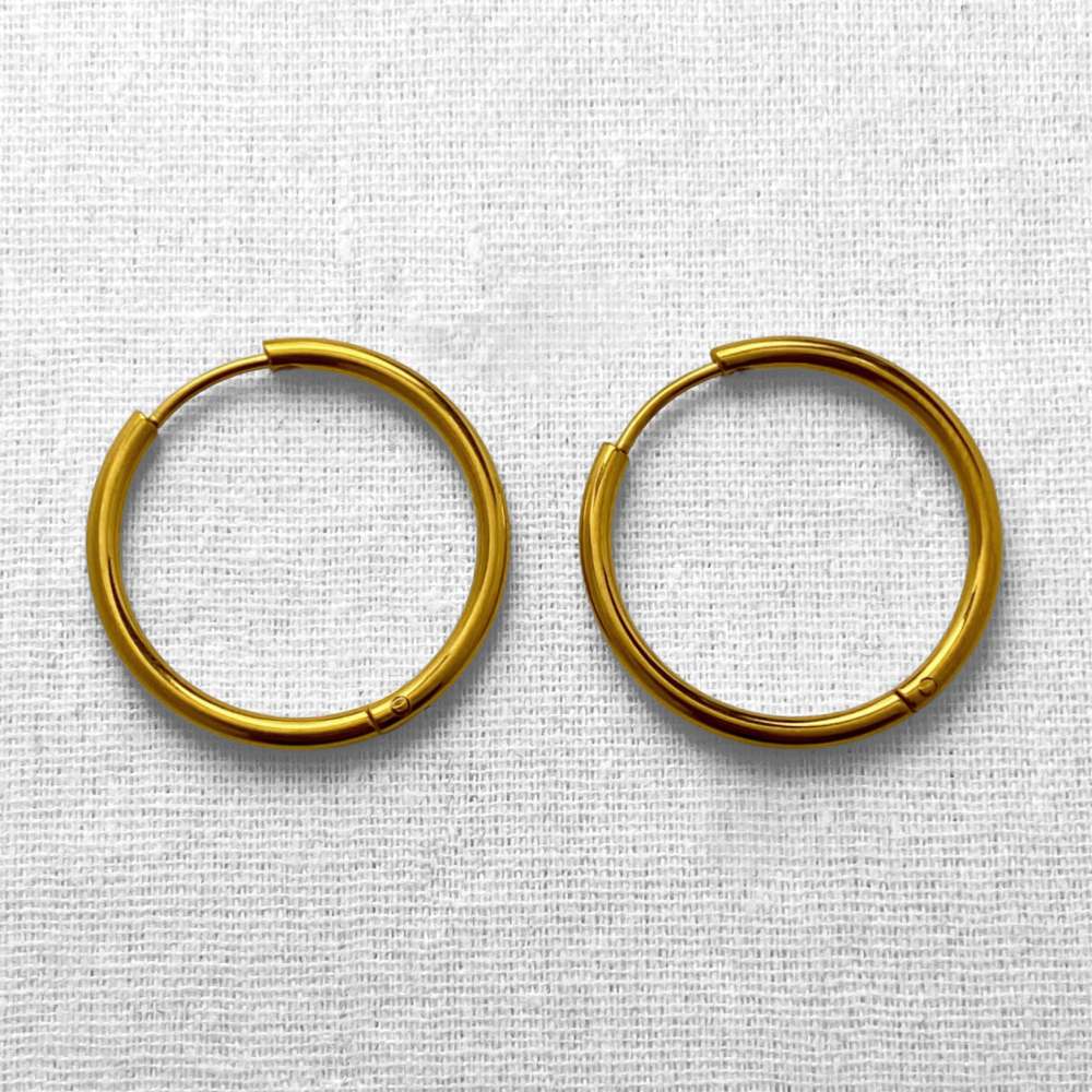 Pair of gold hoop earrings on a textured white background