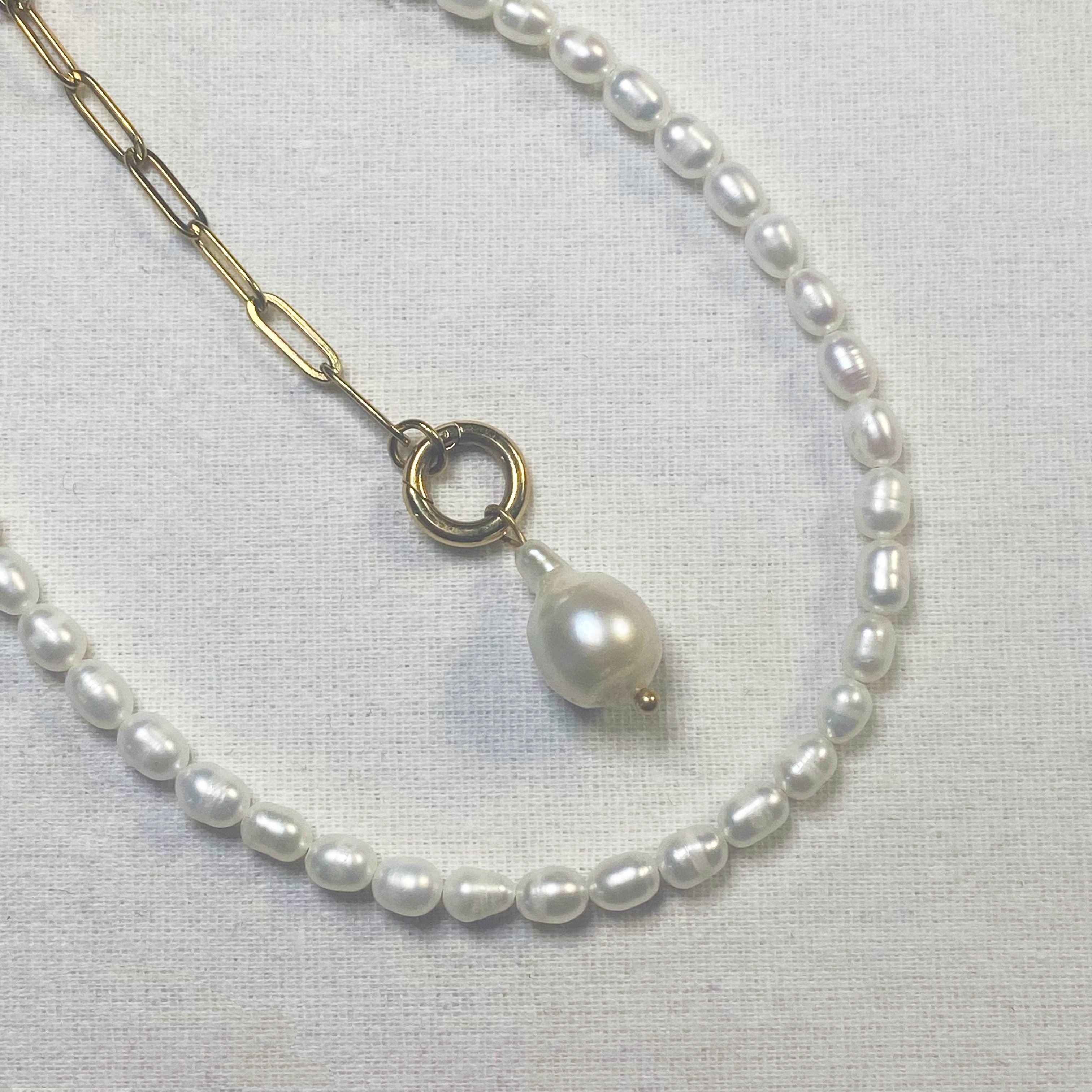Pearl necklace with a pendant on a light gray background and lumenaura jewellery 