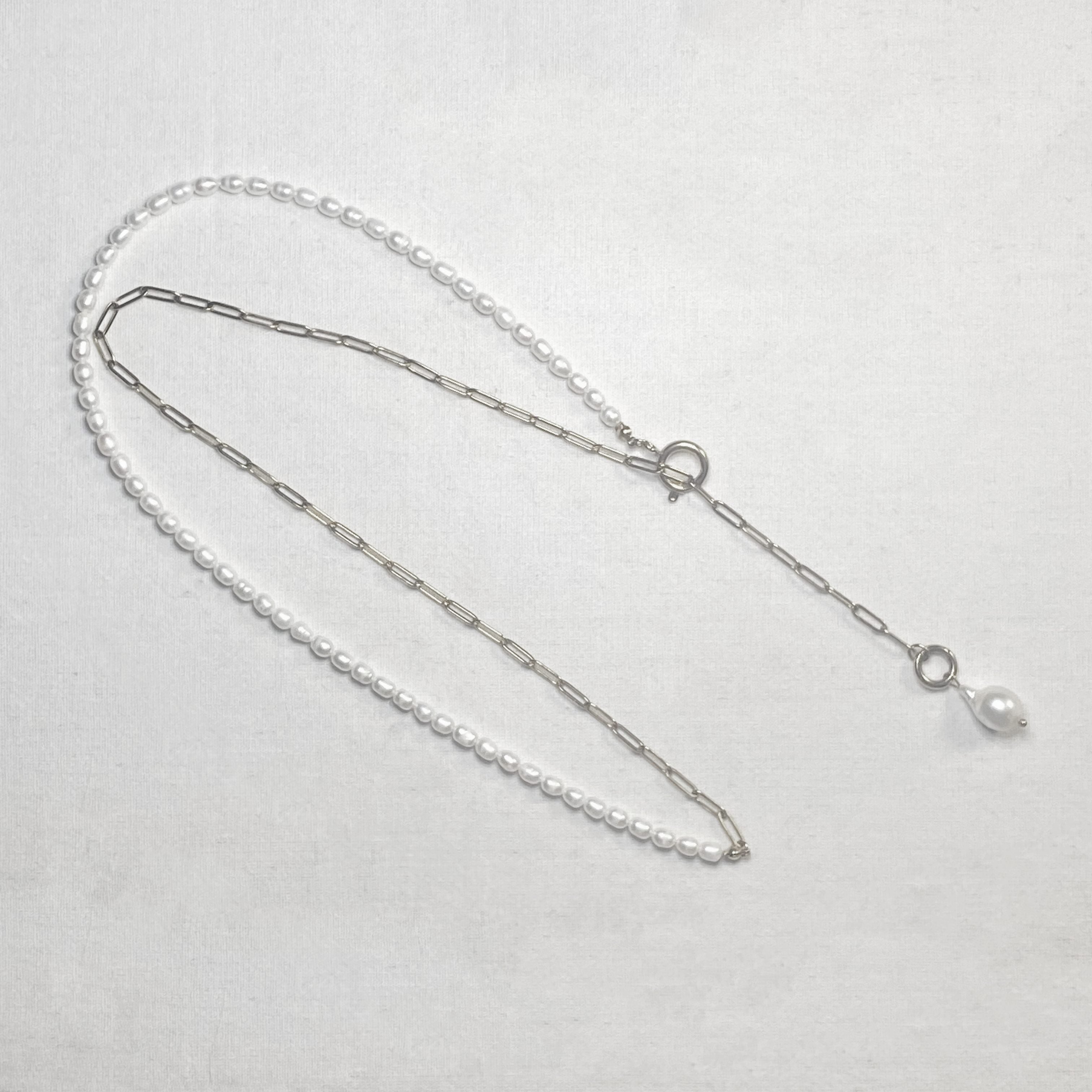 Pearl necklace with a clasp on a light gray background and lumenaura jewellery 