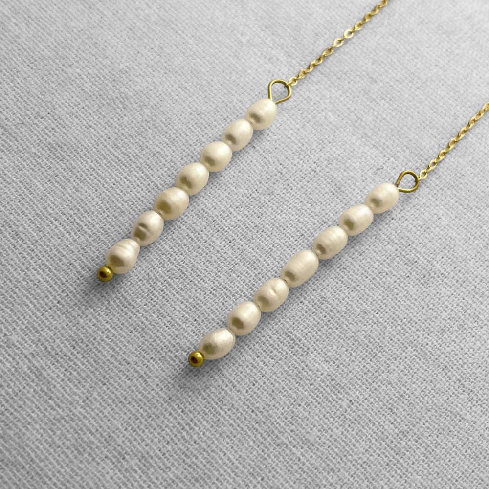 Pearl necklace with gold accents on a beige fabric background
