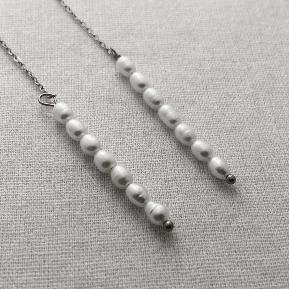 Pearl necklace on a light gray fabric background