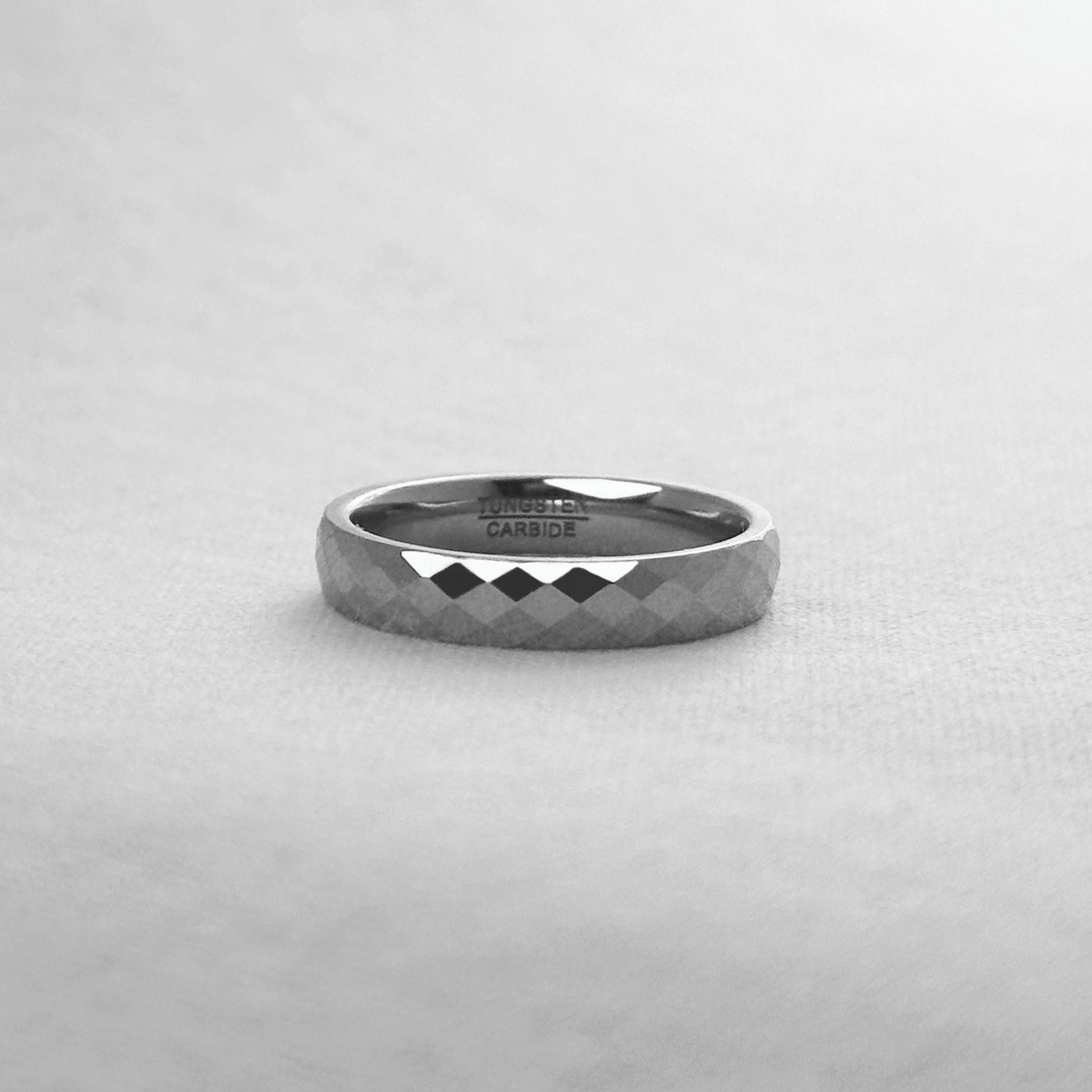 Silver ring with a textured pattern on a light gray background